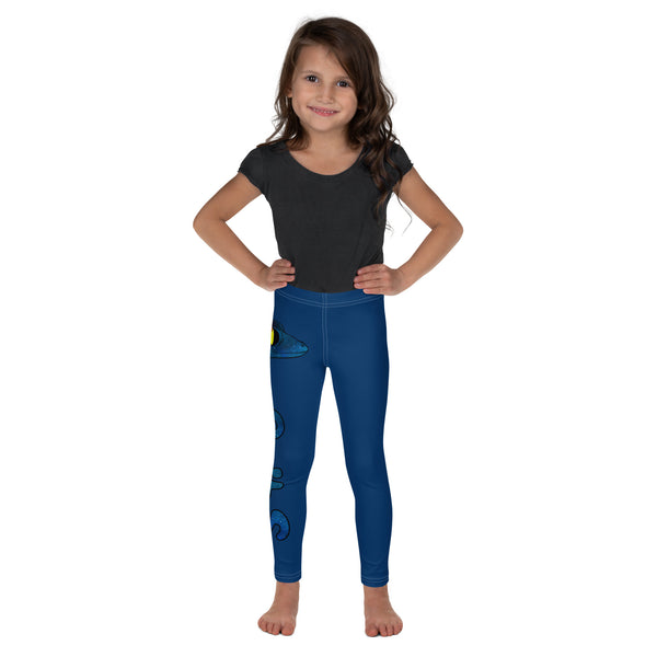 Girl smiling frontview with plain dark grey shirt and blue Luna leggings barefooted with gecko and logo in blue running down side of right leg