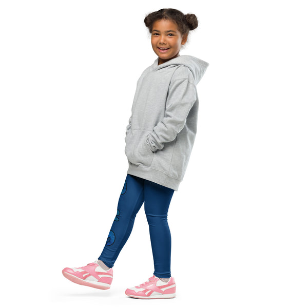 Little girl wearing plain hoodie and blue Luna leggings with pink and white shoes in side view with gecko and logo in blue running down side of right leg